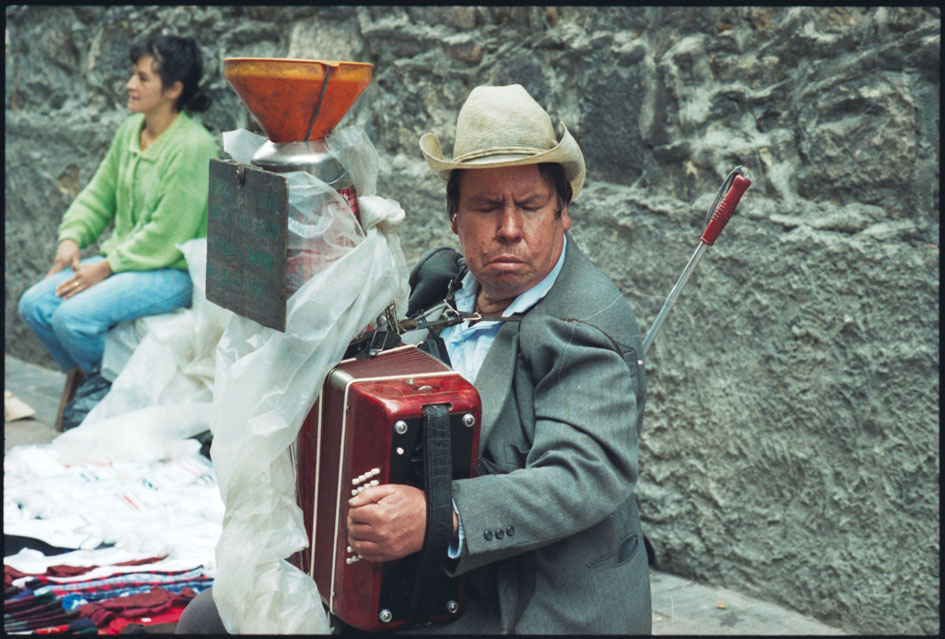 Fotografía de hombre con discapacidad visual tocando un acordeón en las calles de Bogotá. 